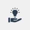 Hand holding a glowing light bulb.